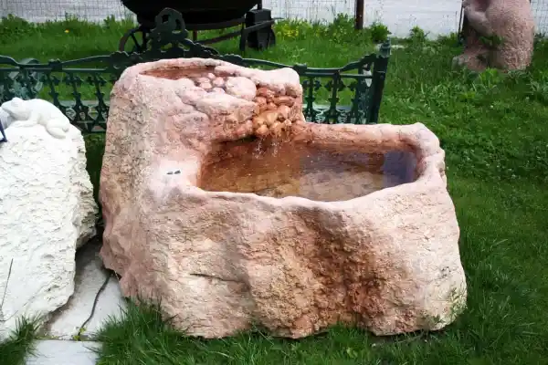 Brunnen mit "Wasserfall" aus rotem Kalkstein